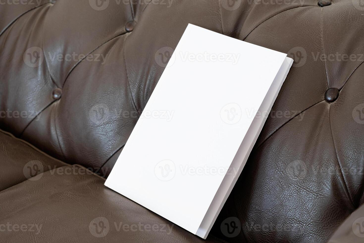 Book with blank cover on leather sofa photo