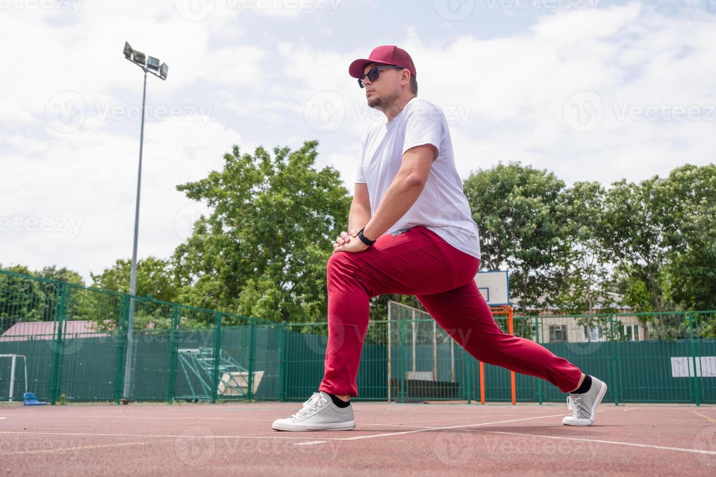 Athletic bearded man warms up before workout at the stadium photo