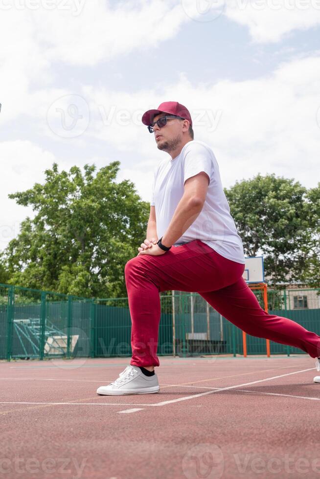 Athletic bearded man warms up before workout at the stadium photo