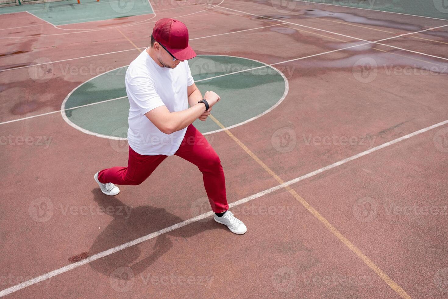 Athletic bearded man warms up before workout at the stadium photo