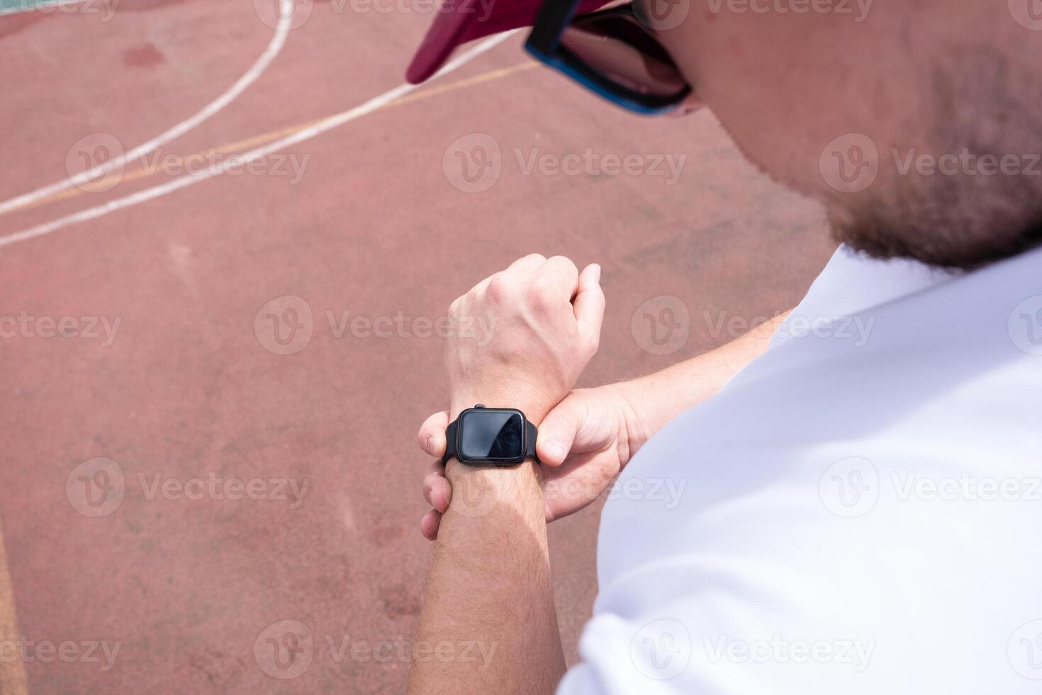 Athletic bearded man warms up before workout at the stadium photo