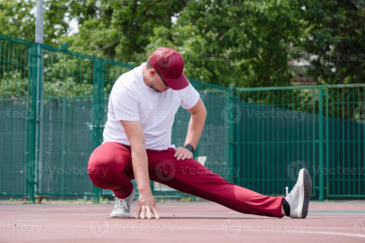 Athletic bearded man warms up before workout at the stadium photo