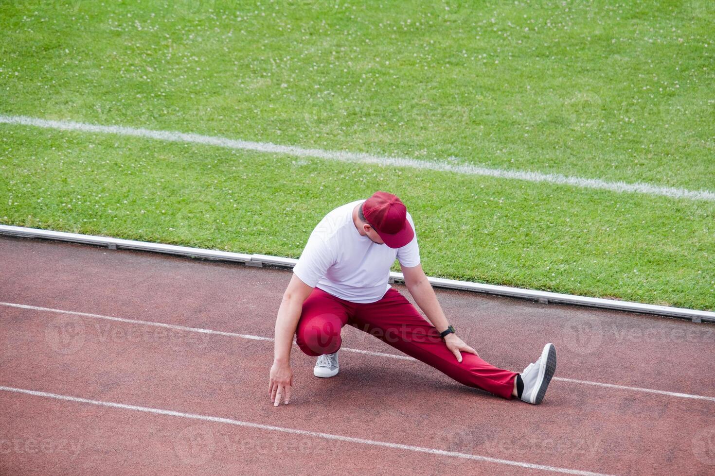 Athletic bearded man warms up before workout at the stadium photo