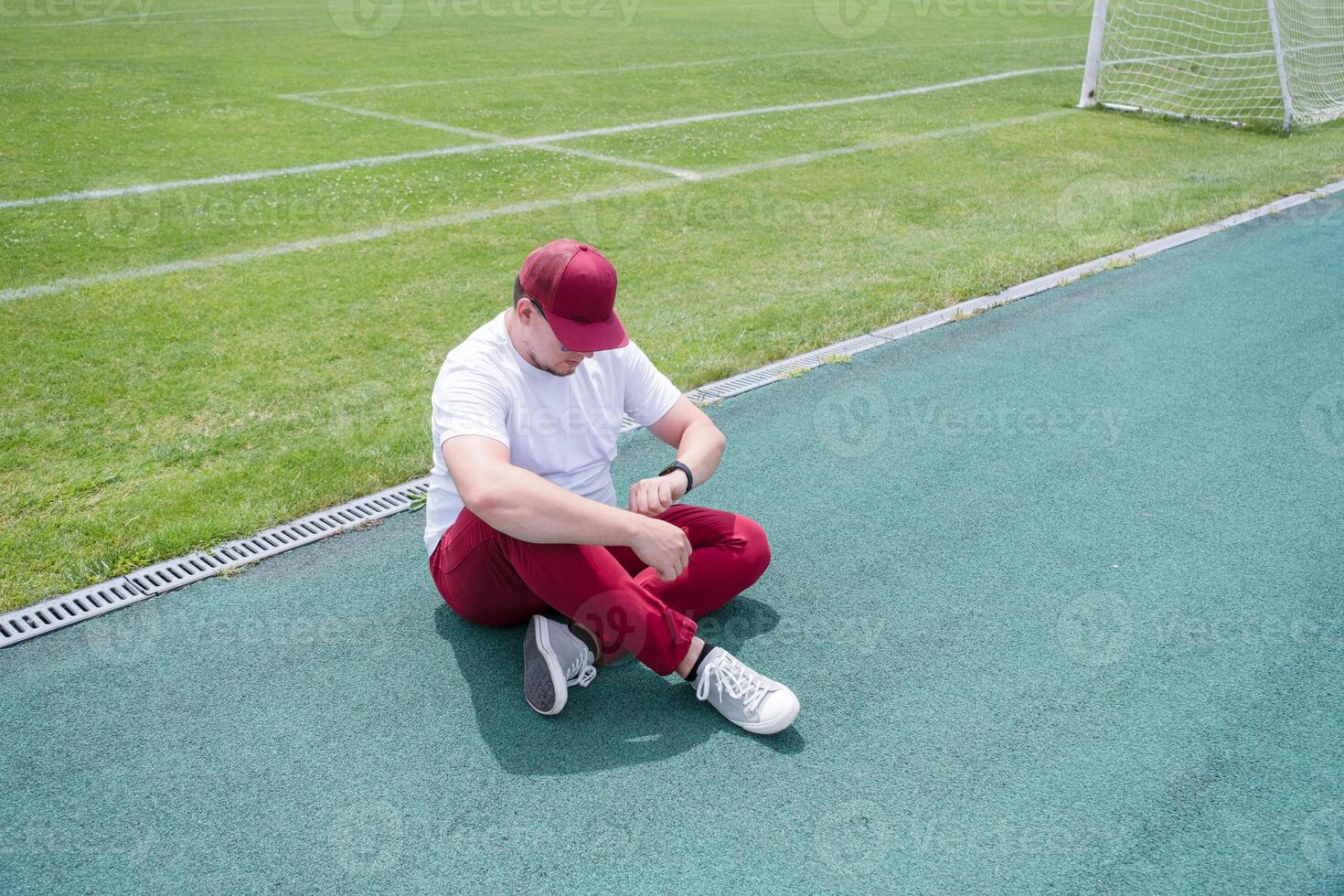 Athletic bearded man resting sitting at the stadium photo