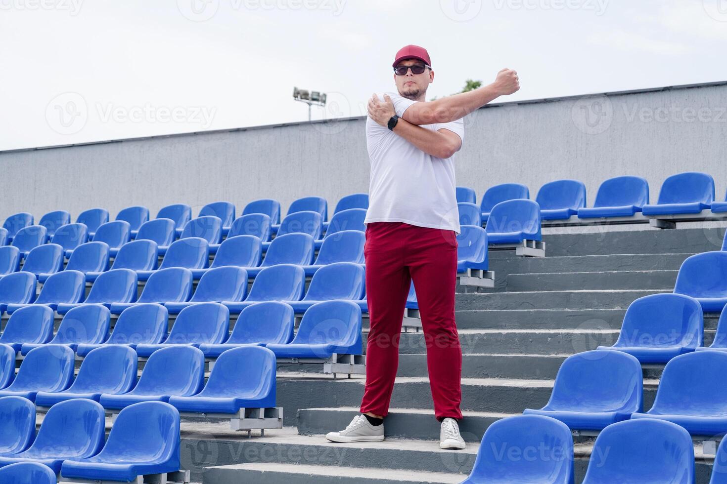 sportsman running in the stadium among blue seats photo