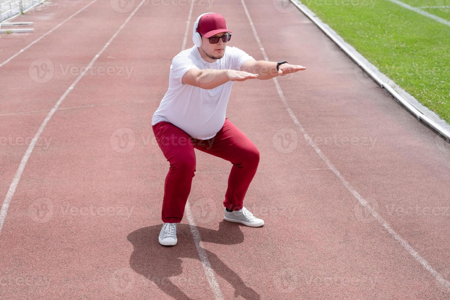 Athletic bearded man warms up before workout at the stadium photo
