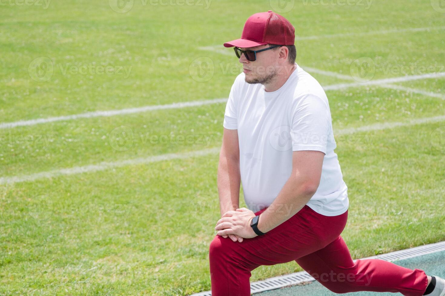 Athletic bearded man warms up before workout at the stadium photo