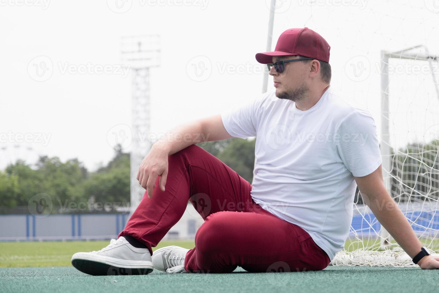 Athletic bearded man resting sitting at the stadium photo