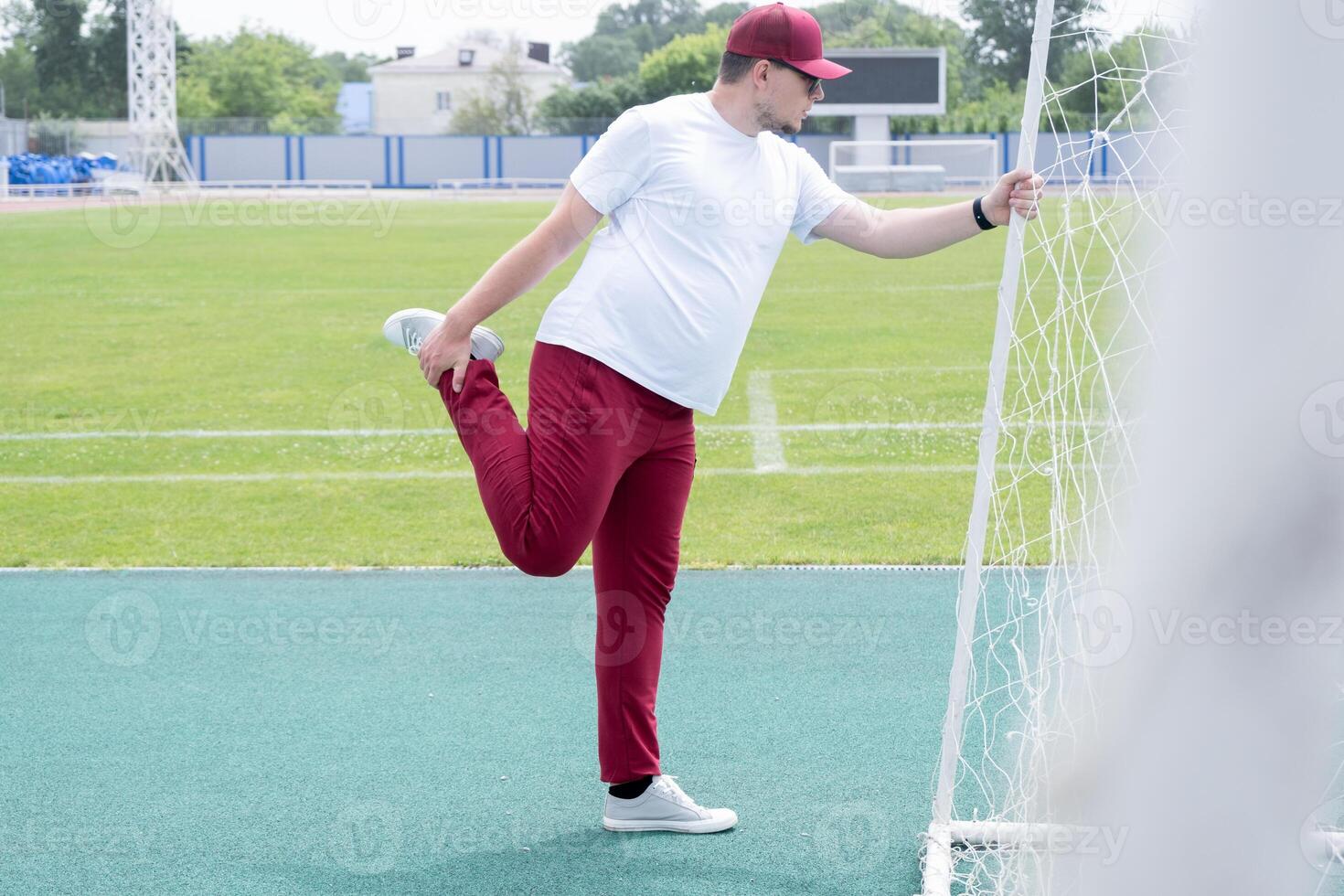 Athletic bearded man warms up before workout at the stadium photo
