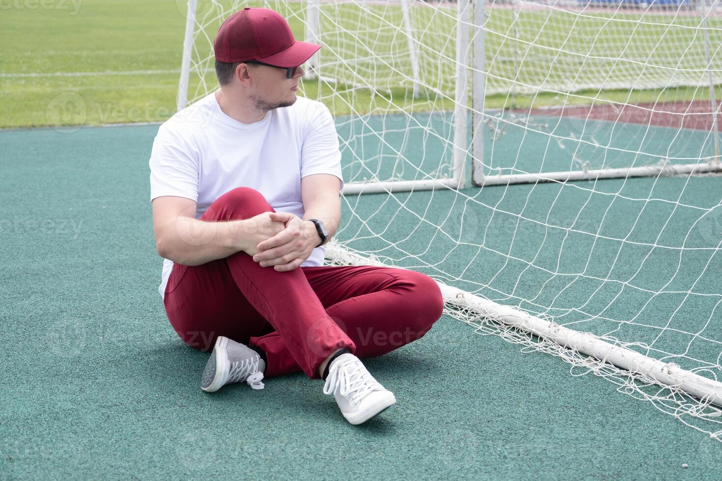 Athletic bearded man resting sitting at the stadium photo