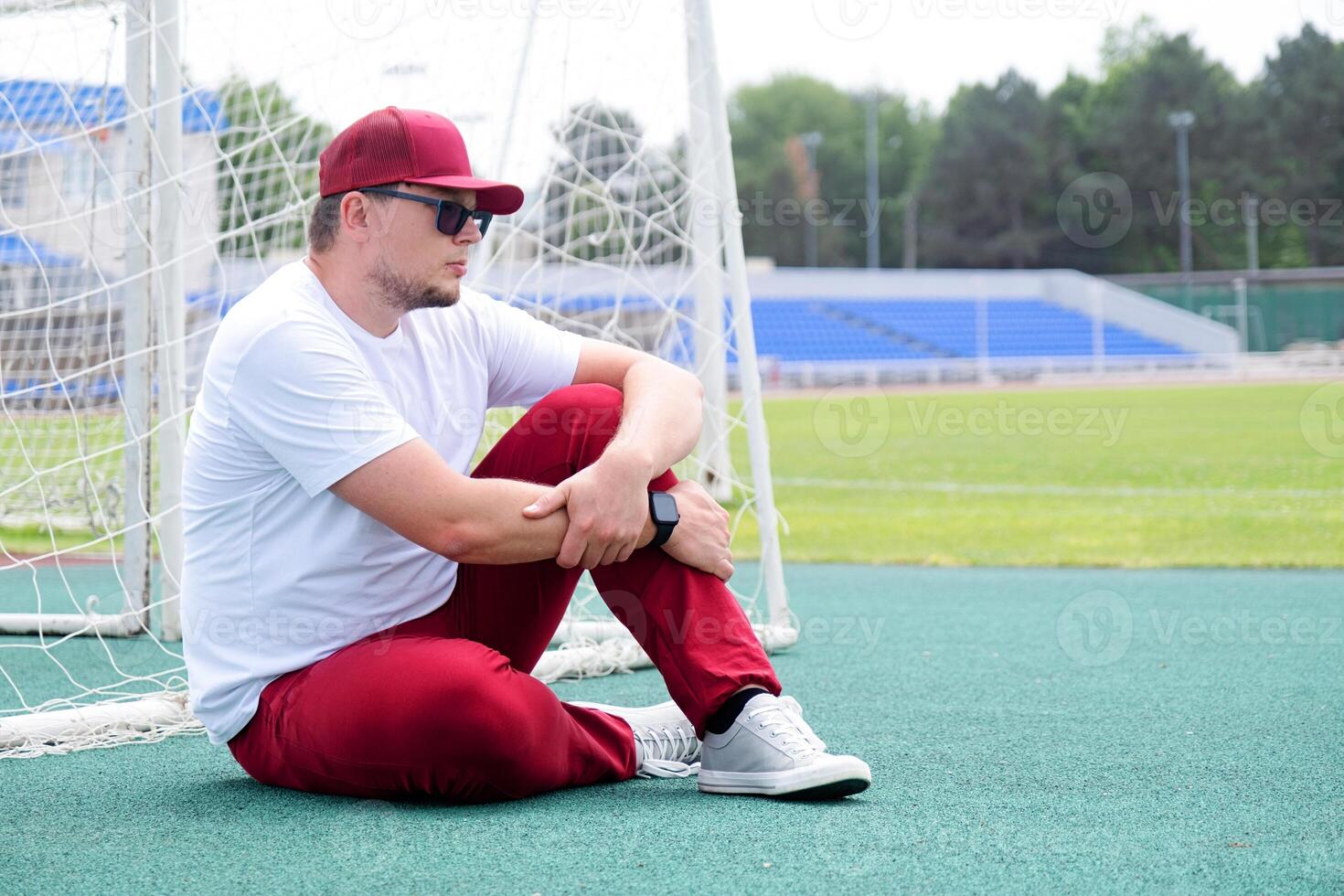 Athletic bearded man resting sitting at the stadium photo