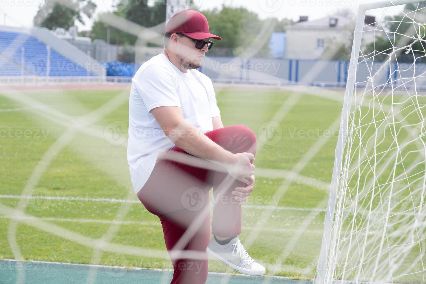 Athletic bearded man warms up before workout at the stadium photo