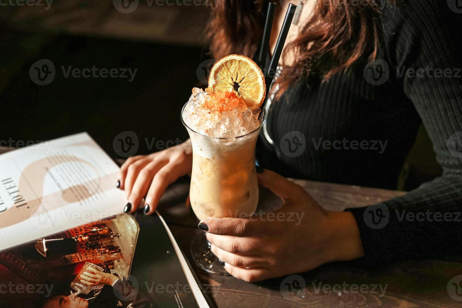 Woman Reading Book and Enjoying Drink at Table photo