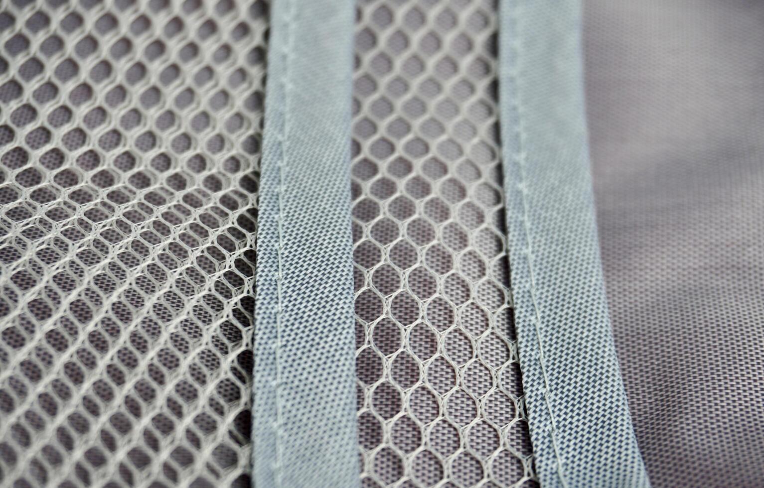 Inside part of travel bag pouch organizer compartment for storing make up, medicine, and other small objects. Gray net bag isolated on horizontal ratio background. photo