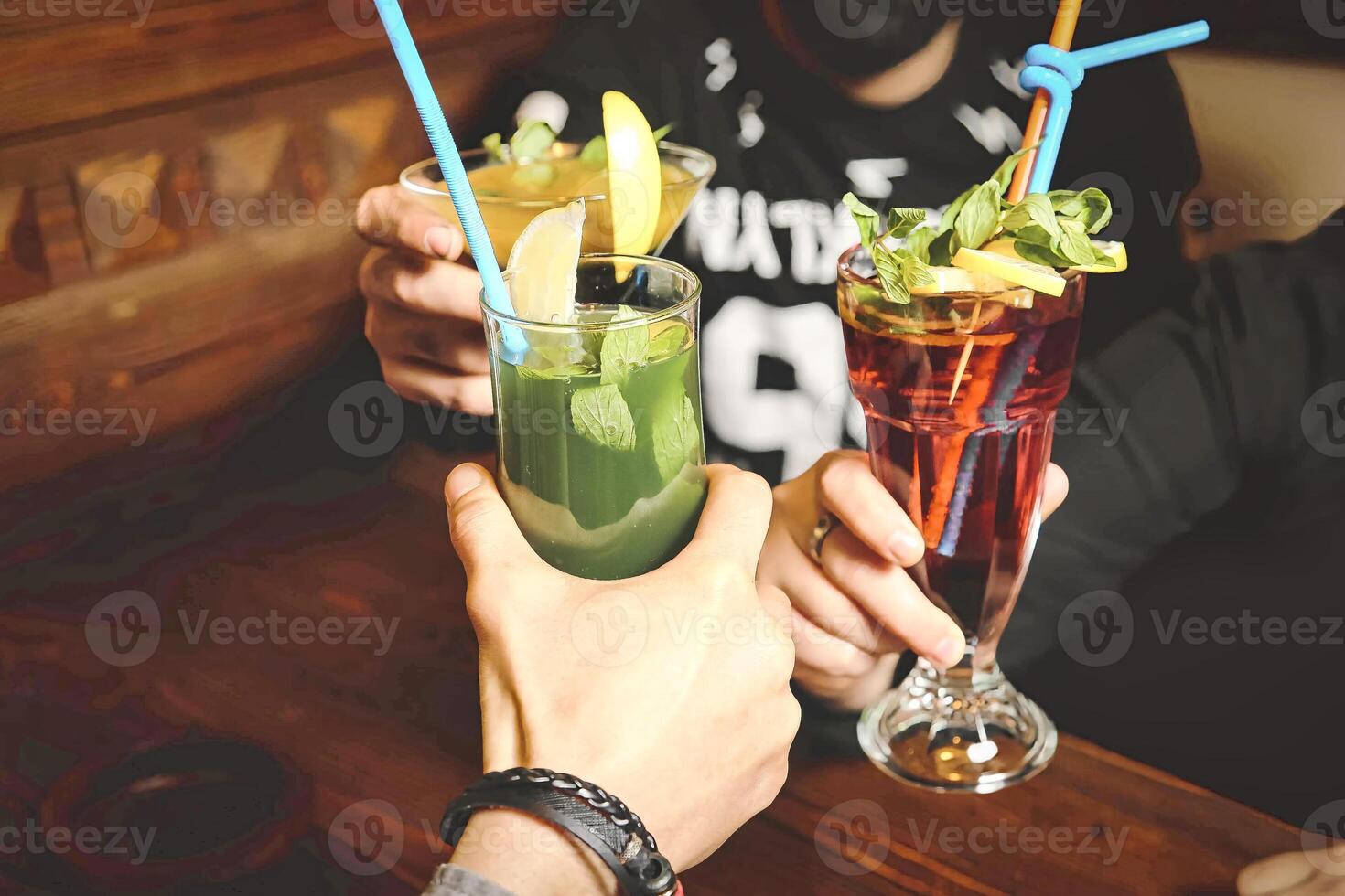 Group of People Sitting at a Table With Drinks, Enjoying a Social Gathering. photo
