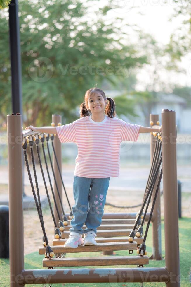 A young girl is walking across a wooden bridge photo