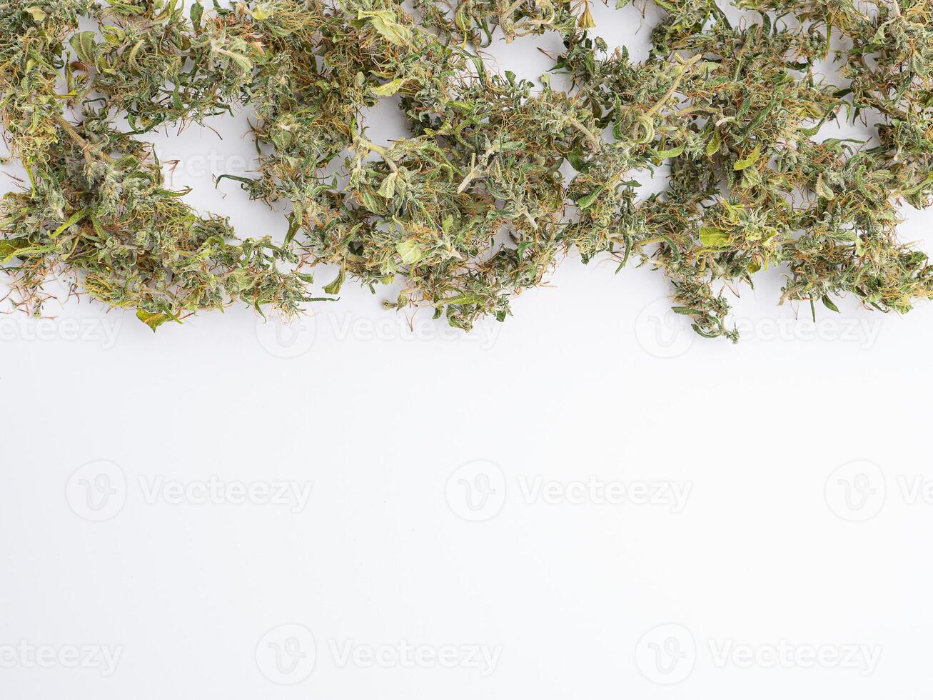 A pile of cannabis buds on white background. The texture of marijuana leaves. Space for text. Concept of cannabis plantation for medical photo