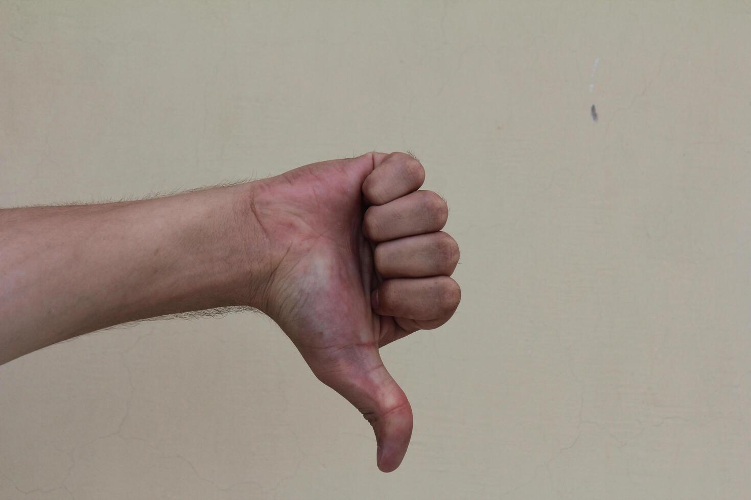 Thumb down male hand sign isolated photo