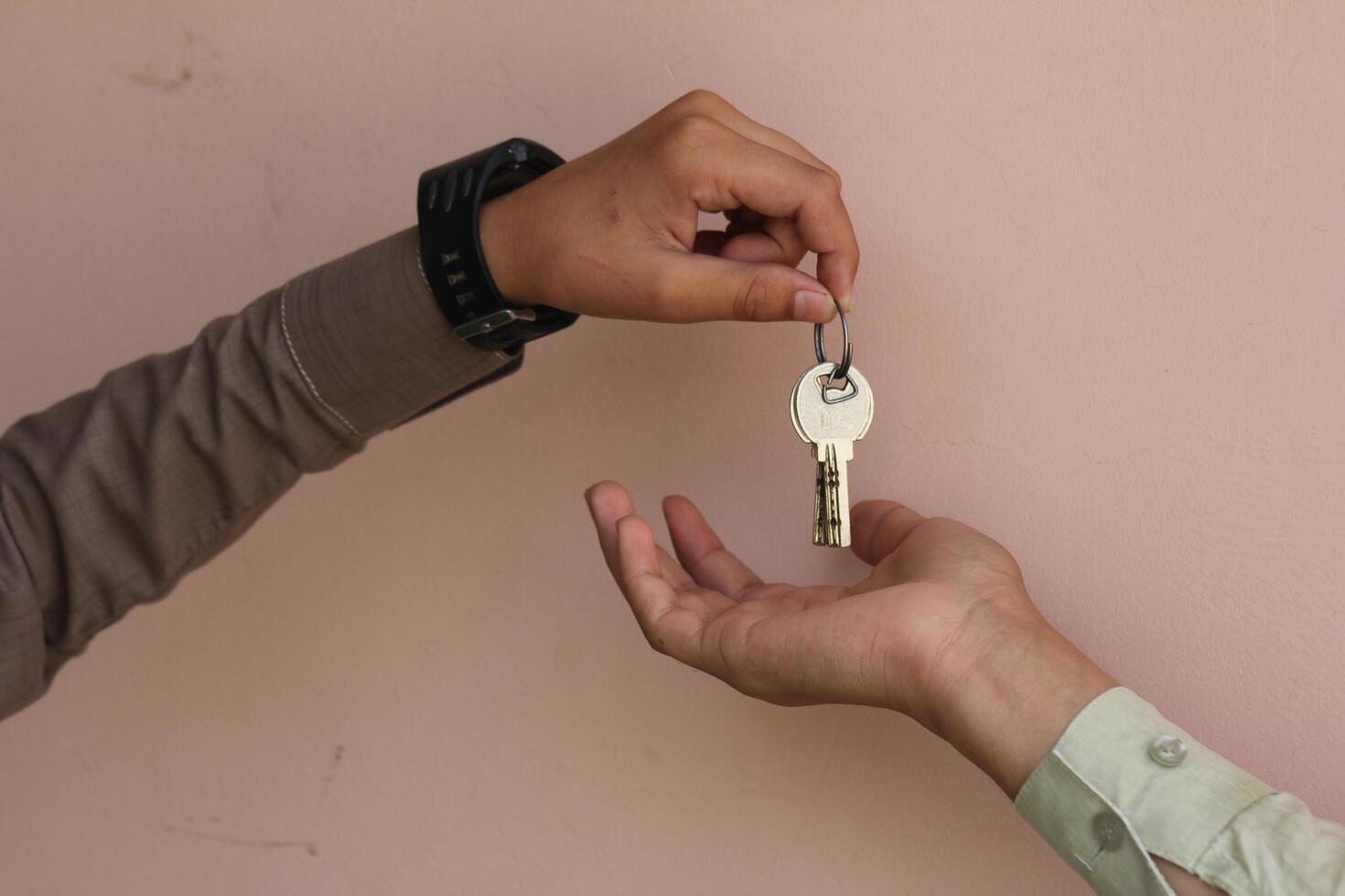 Real estate agent giving keys to apartment owner, buying selling property business. Close up of male hand taking house key from realtor. Mortgage for purchasing flat, getting access to own home photo