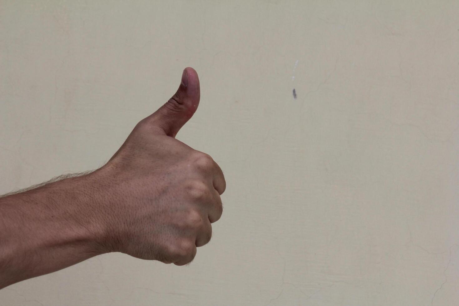 Closeup of male hand showing thumbs up sign photo