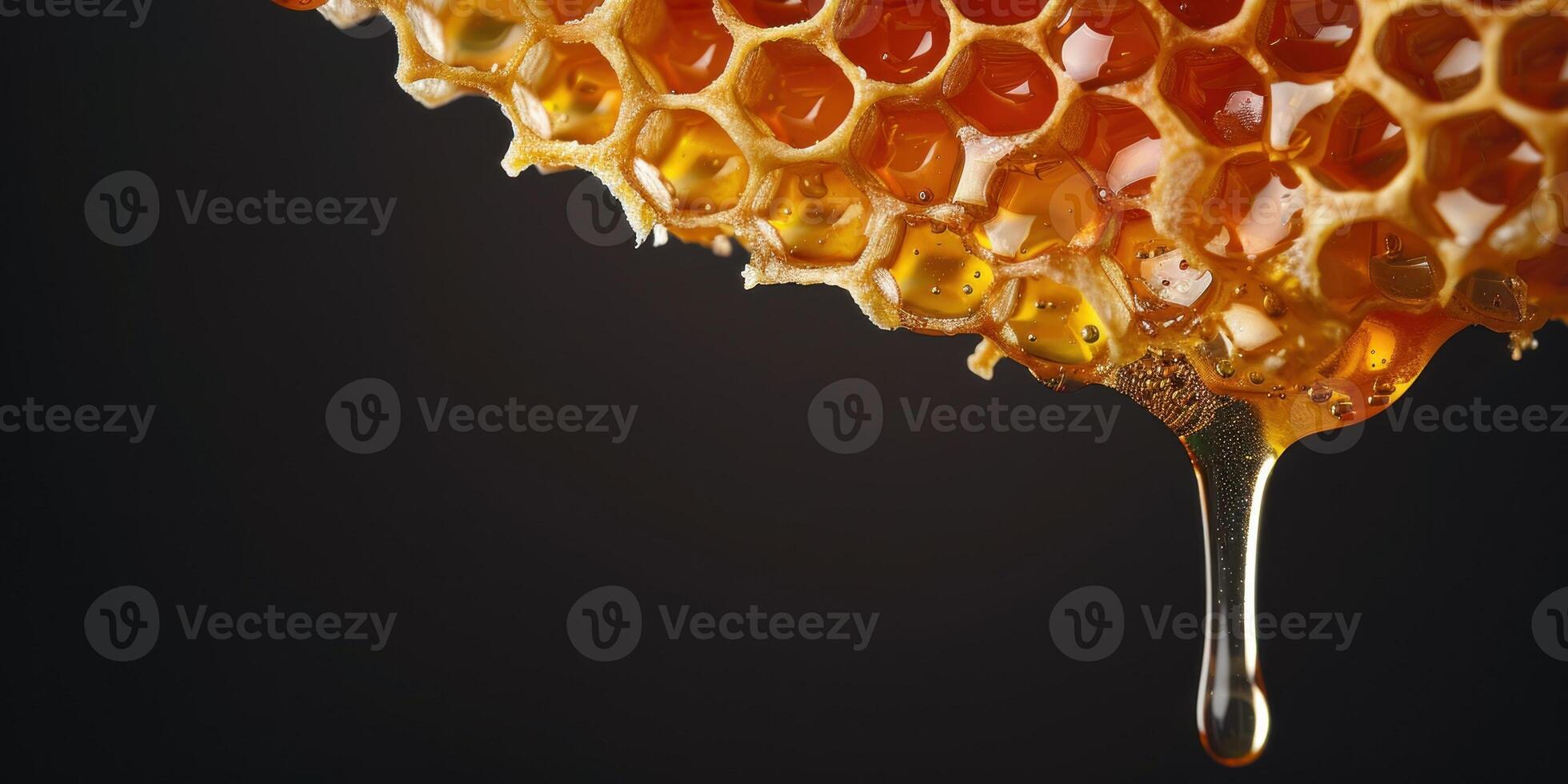 Honey dripping from honeycomb on black background photo