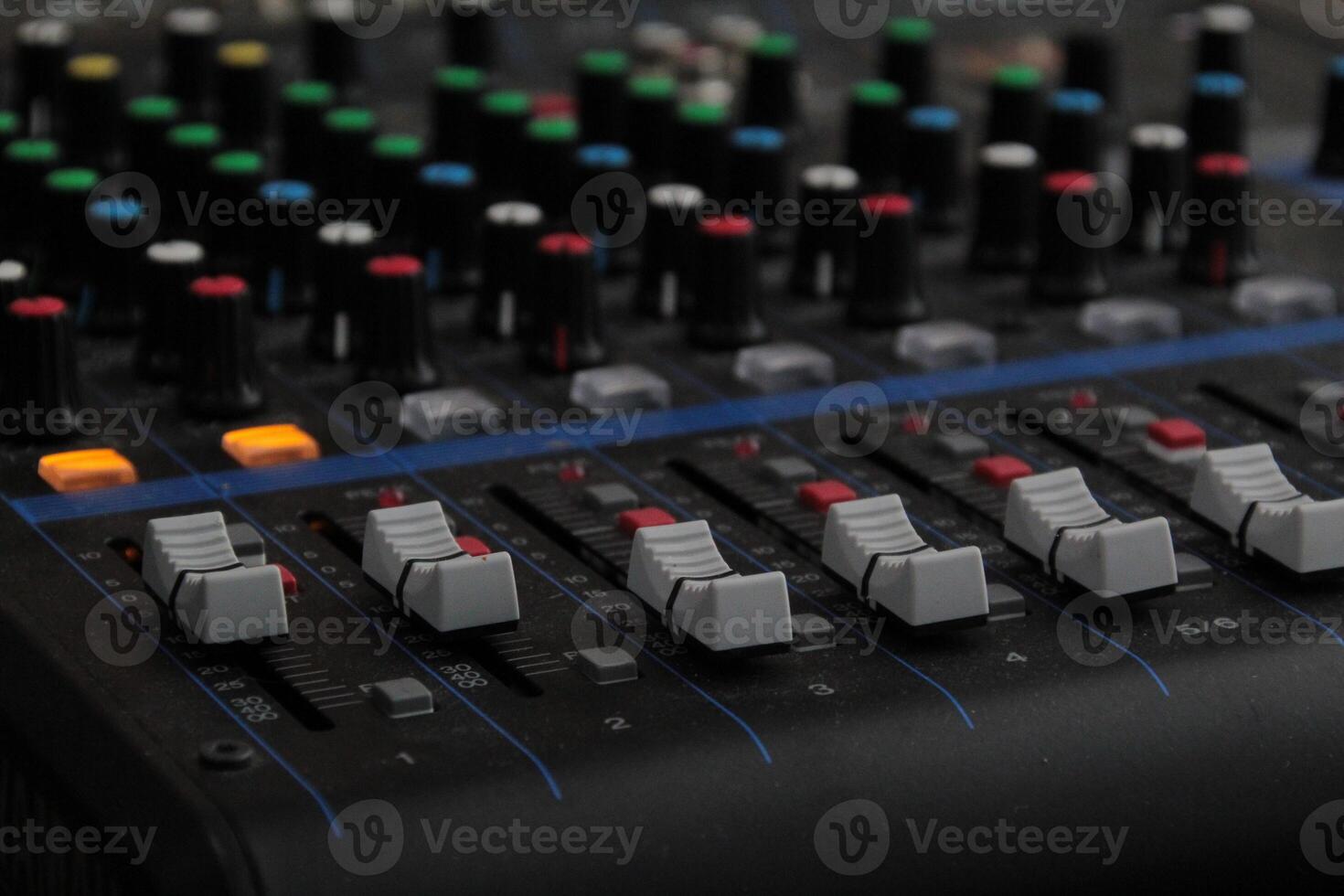 Close-Up View of an Audio Mixer with Numerous Knobs and Controls photo