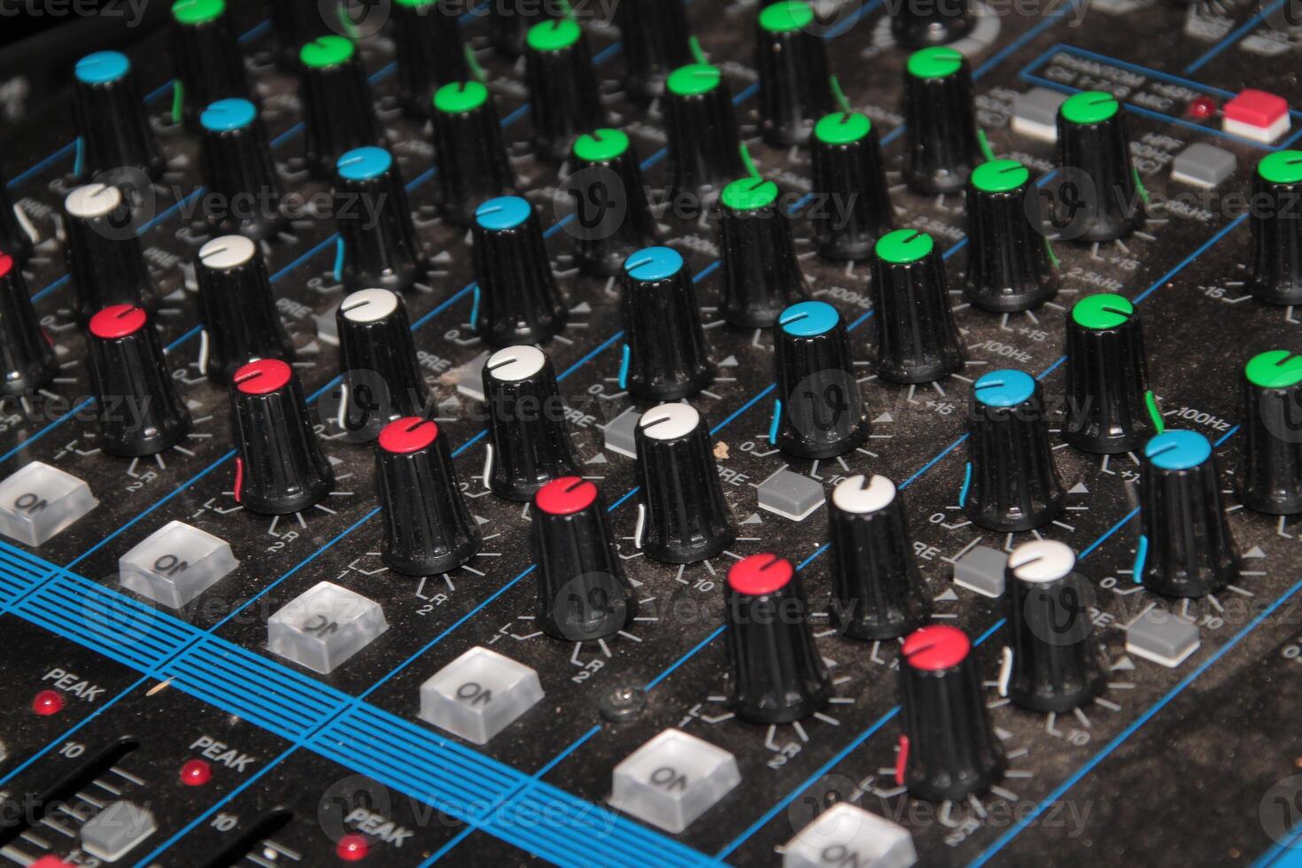 Close-Up View of an Audio Mixer with Numerous Knobs and Controls photo