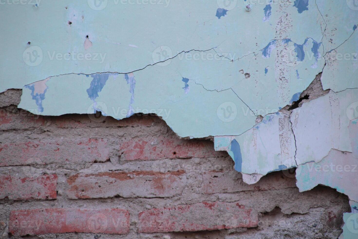 Aged Weathered Brick Wall with Cracked Paint and Exposed Bricks photo