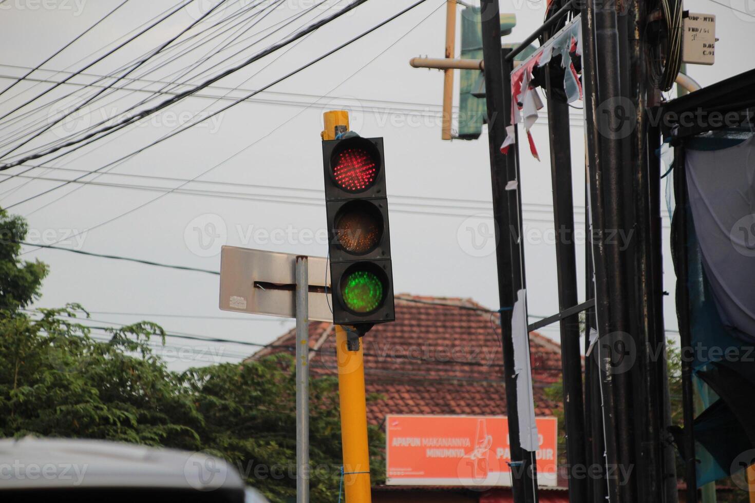 Traffic lights at urban intersection with electricity poles in the background photo