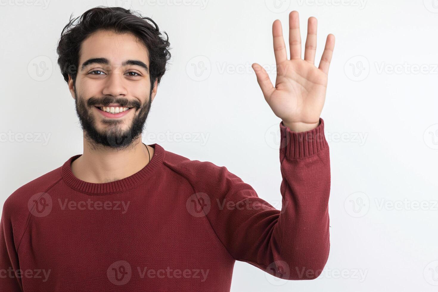 Friendly Young Man with Beard Wearing Red Sweater Waving Hello in Studio Portrait on White Background photo