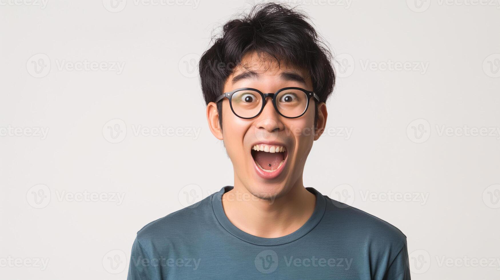 Surprised Asian Man with Glasses and Blue Shirt Expressing Astonishment in Studio photo