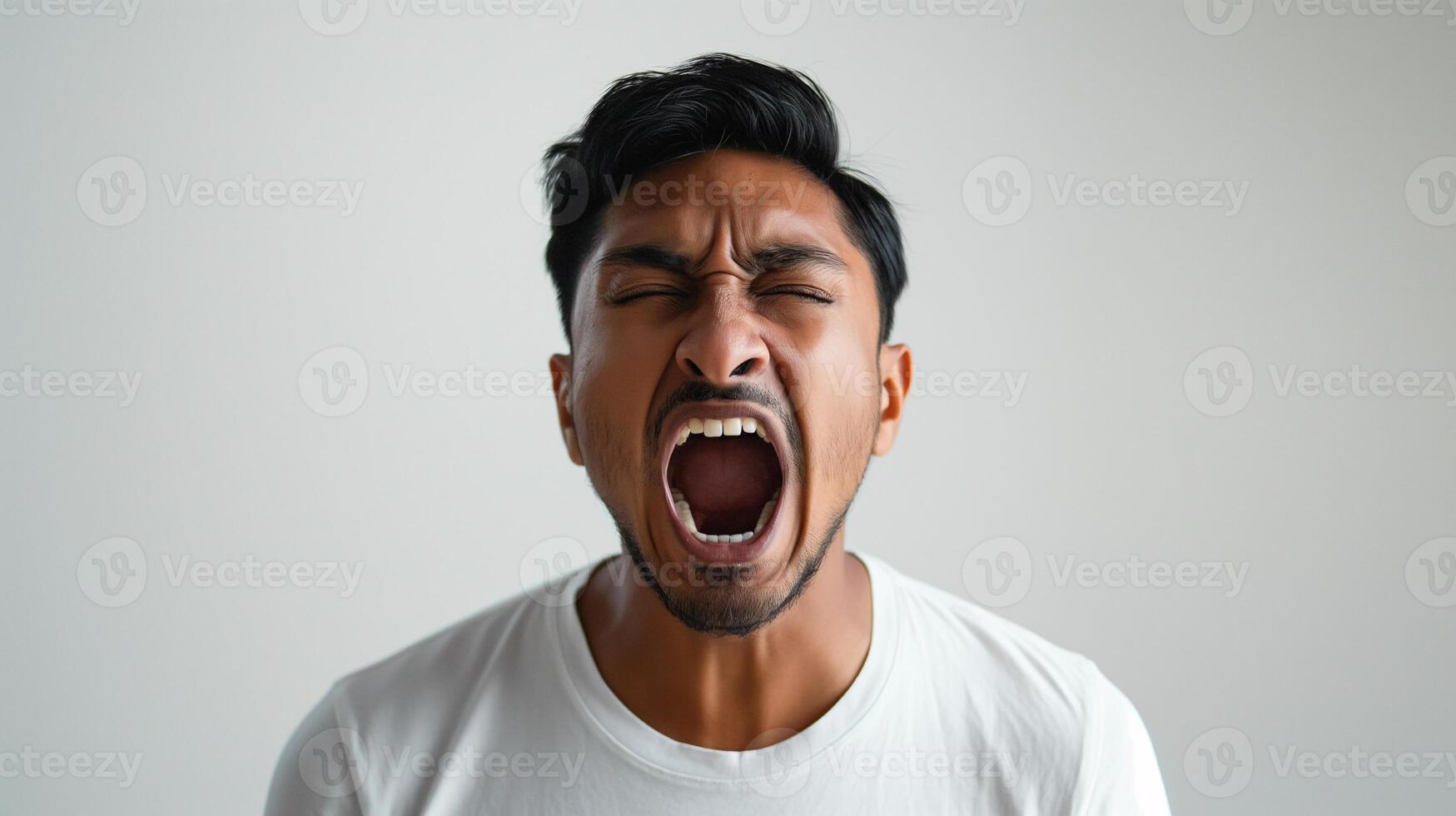 Angry South Asian Man Yelling Loudly, Indoor Close-Up Portrait in White Shirt photo
