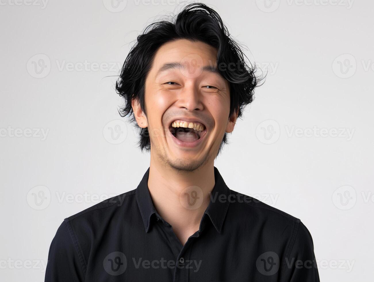 Young Asian Man in Black Shirt Laughing Out Loud on Plain Background, Expressing Joy and Amusement photo