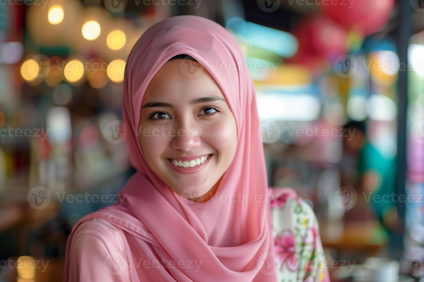 Smiling Young Woman in Pink Hijab at a Vibrant Indoor Market with Colorful Background photo