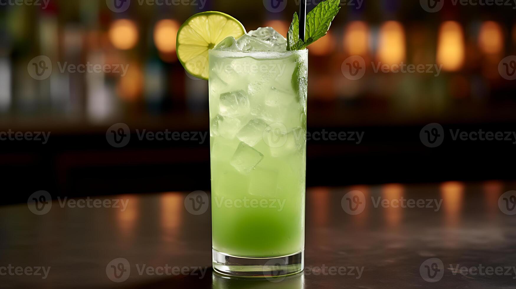 A glass of limeade sits on a wooden table. photo