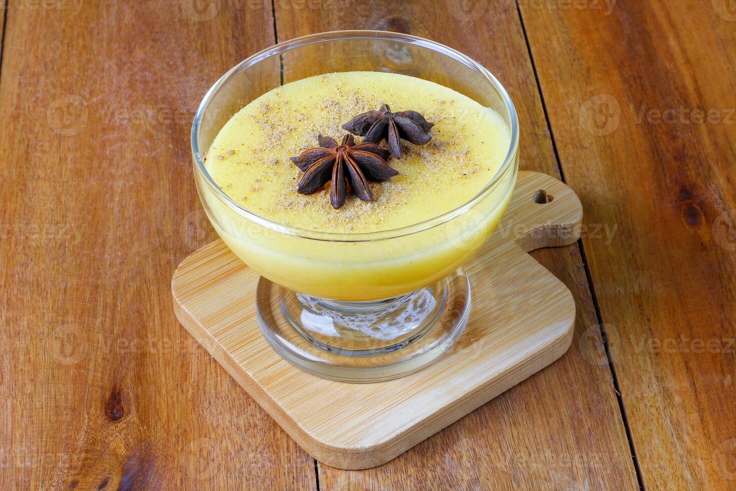 Curau, cream of corn sweet and dessert typical of the Brazilian cuisine, placed in glass bowl on wooden table. photo