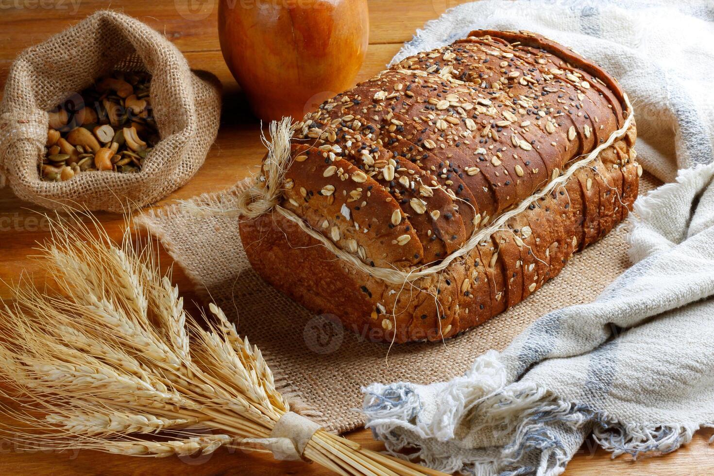 Wholemeal wheat bread or integral bread with grains and seeds sliced on wooden table photo
