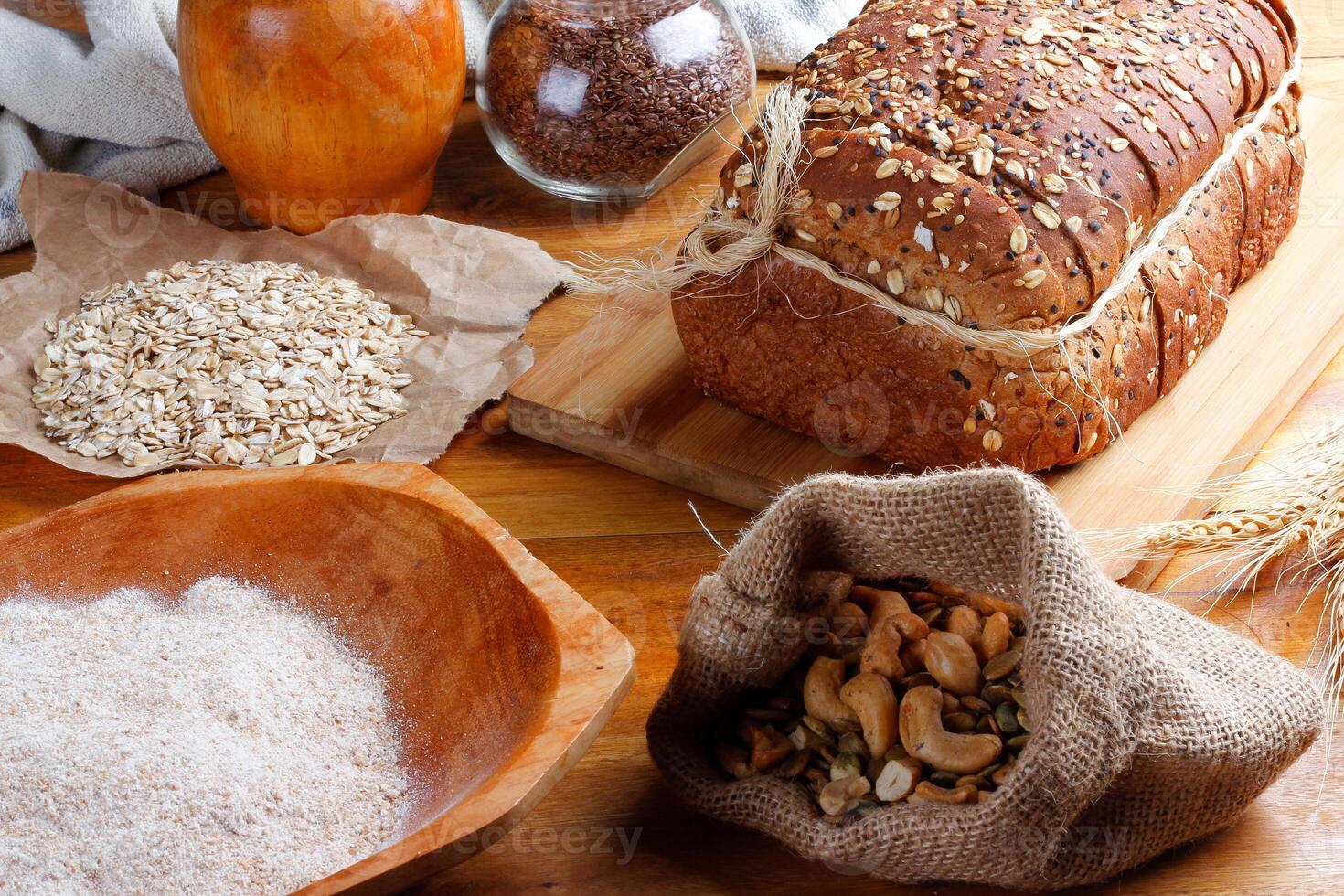 Wholemeal wheat bread or integral bread with grains and seeds sliced on wooden table photo