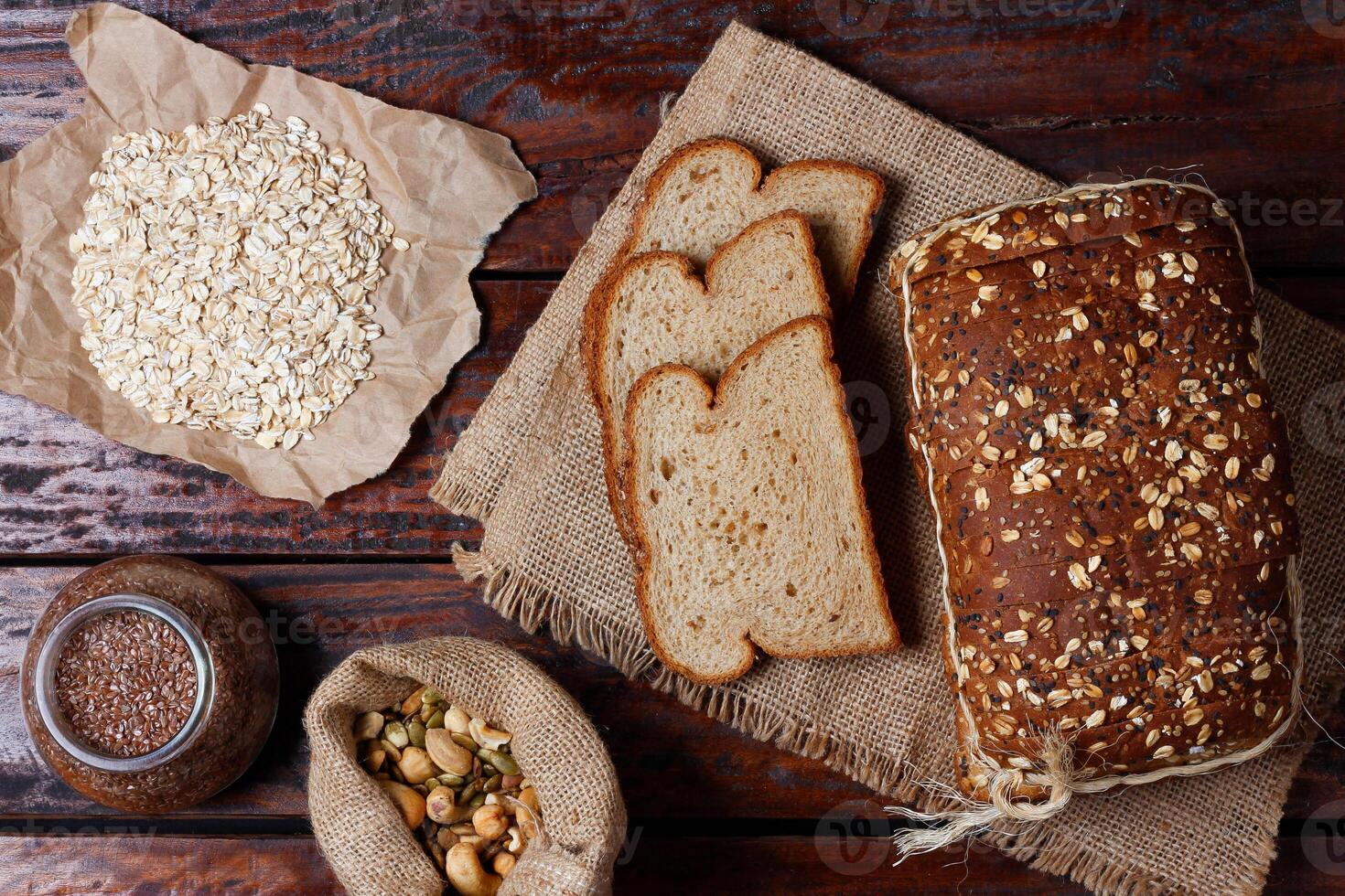Wholemeal wheat bread or integral bread with grains and seeds sliced on wooden table photo
