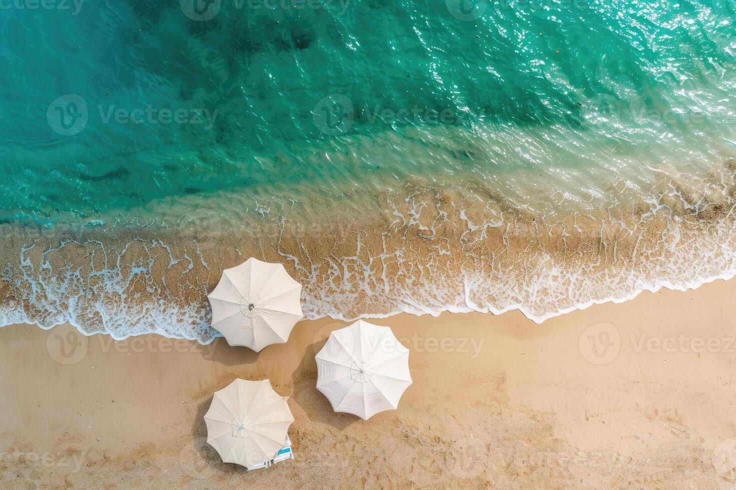 Top view of an umbrella on a tropical sandy beach. Blue, turquoise transparent water surface of the ocean, sea background with copy space. Holidays and summer vacation empty banner photo