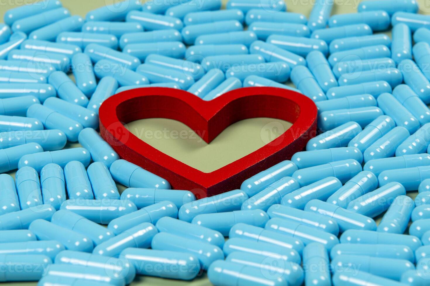 heart shape and blue capsules. Importance of medication treatment photo