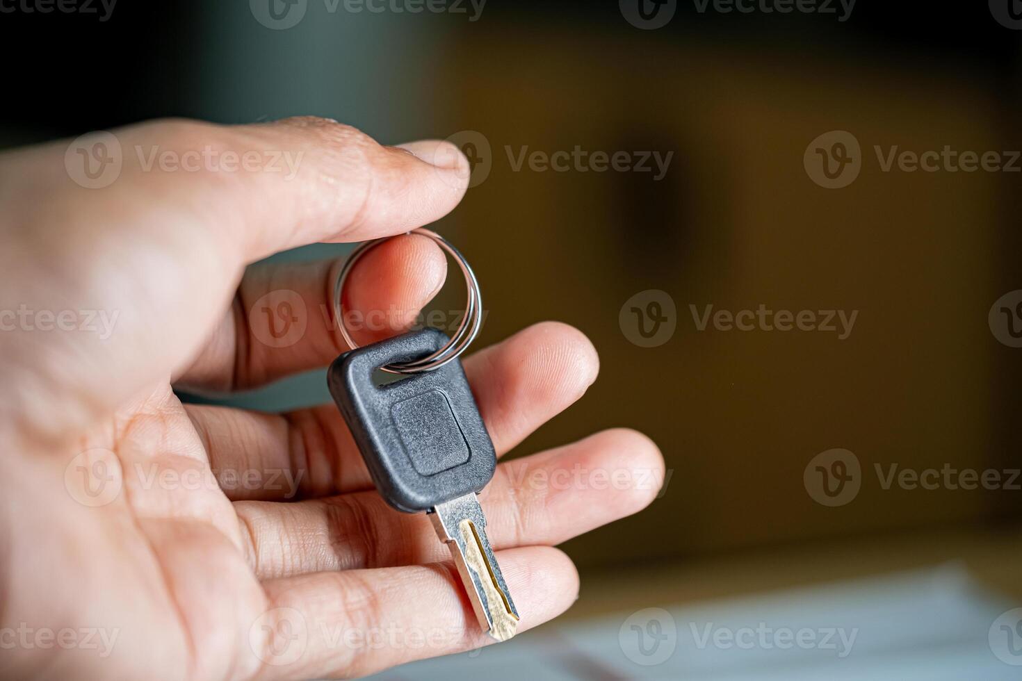 Hand holding car key close-up photo
