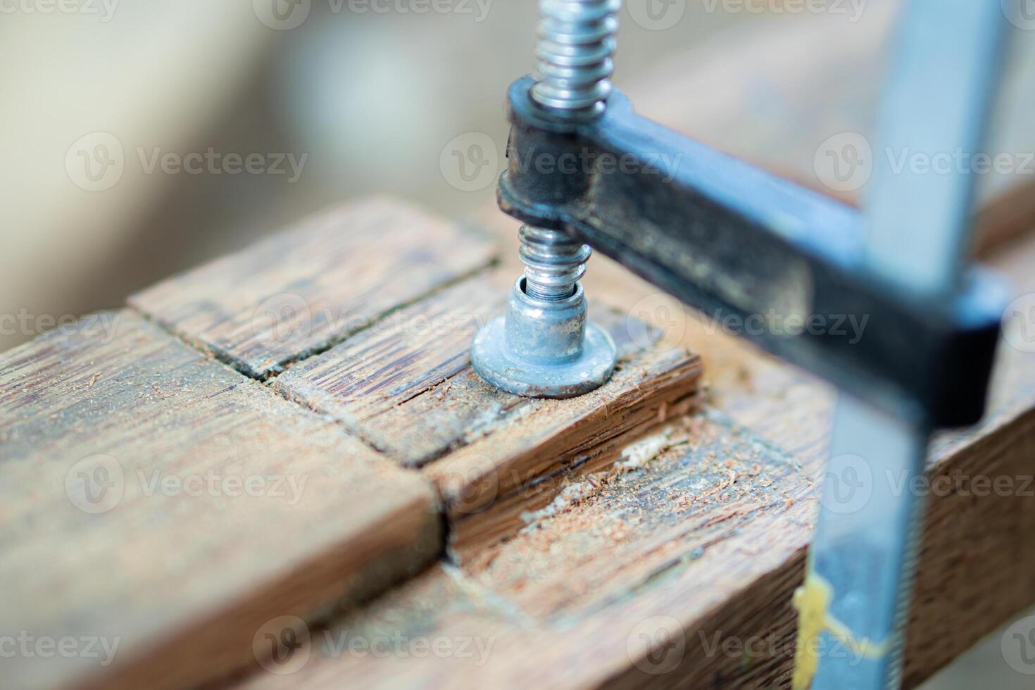 Close-up of a clamp holding wood pieces together photo