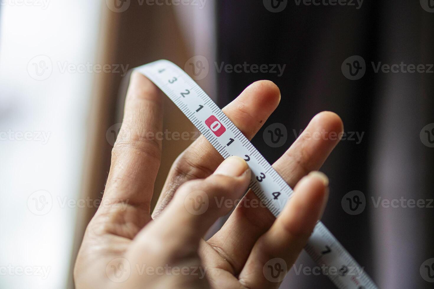 Hand Holding Measuring Tape Close-Up photo