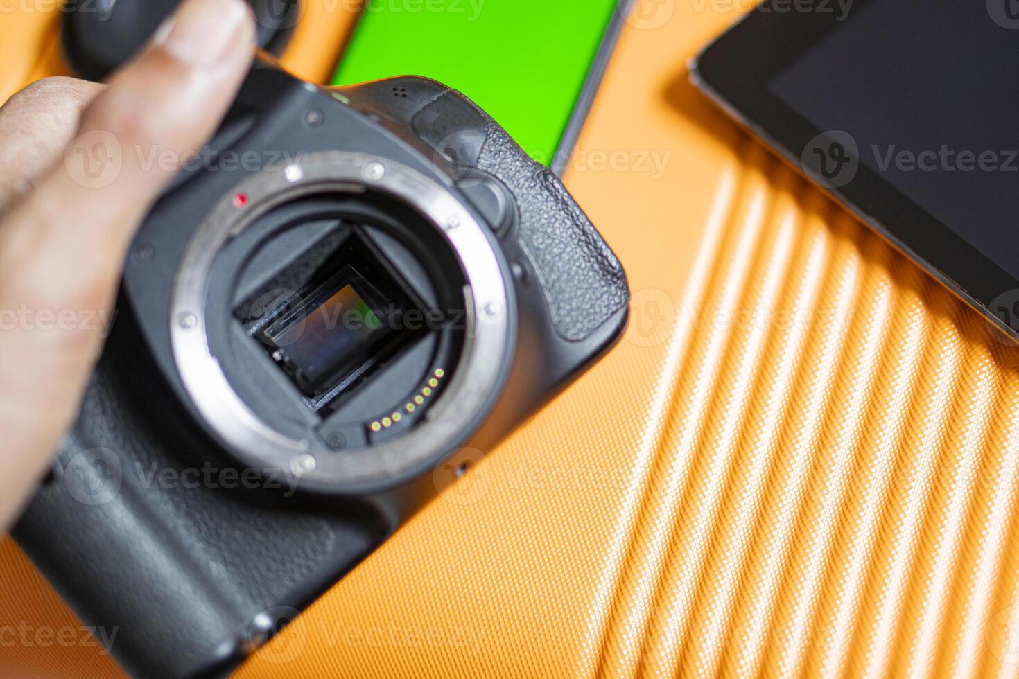 SLR camera and tablet on orange surface photo
