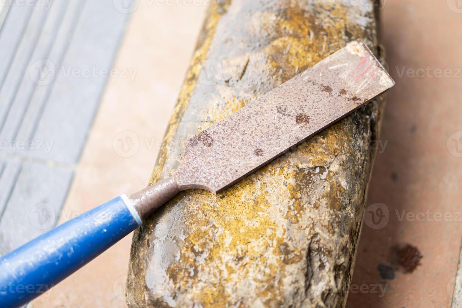 Rusty chisel on weathered sharpening stone photo