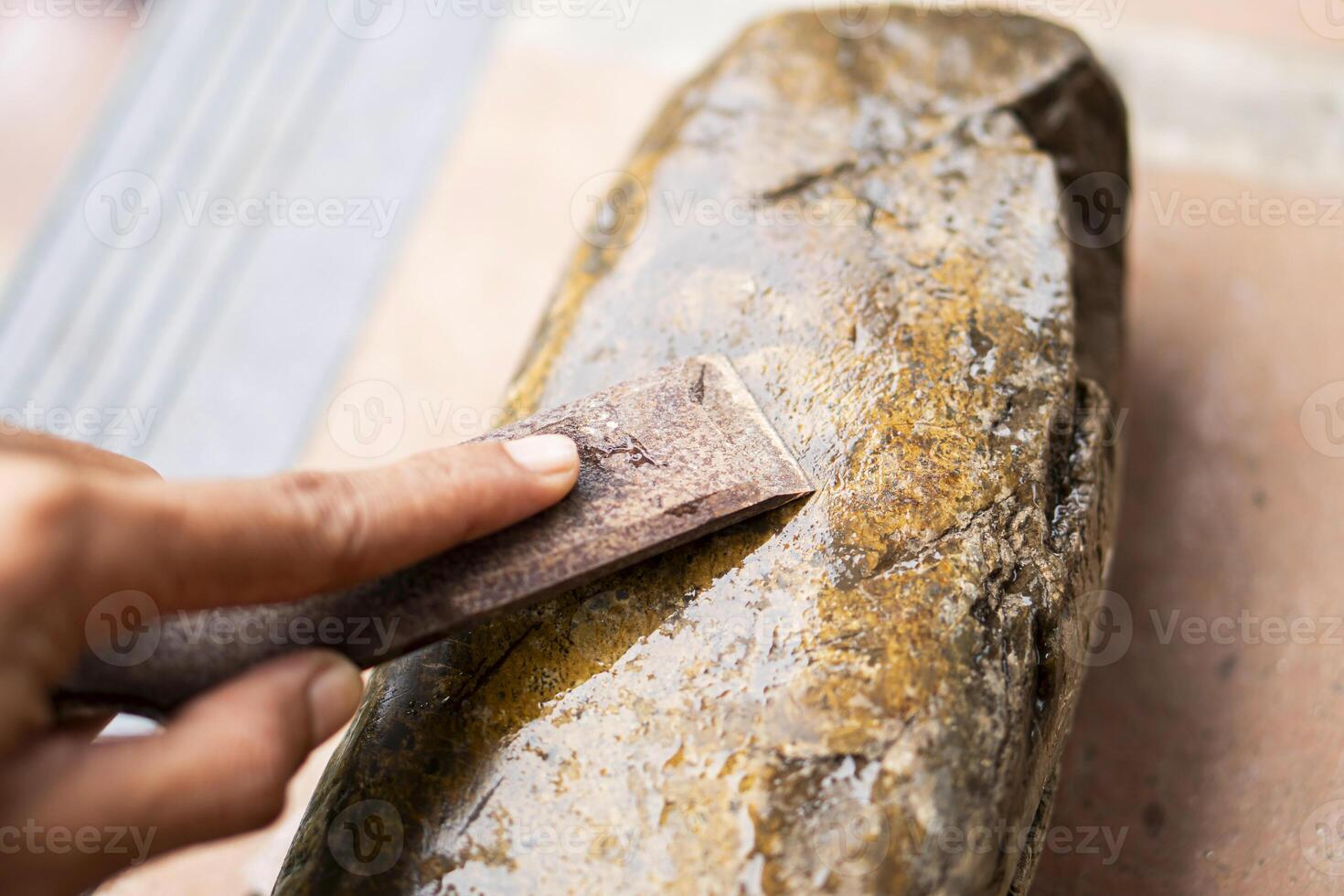 Sharpening a tool on a whetstone photo