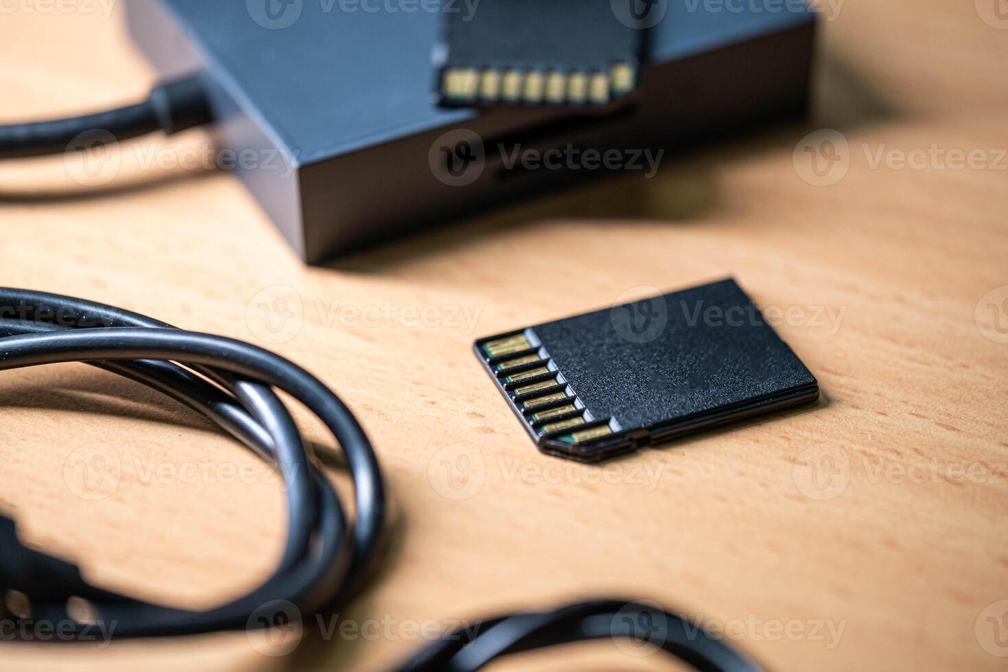 SD memory cards and card reader on wooden surface photo