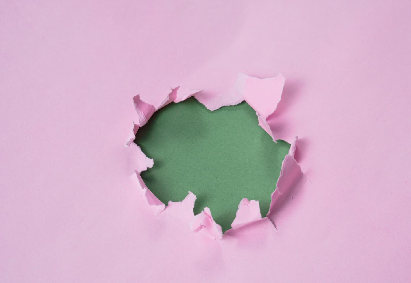 Ripped or torn pink paper frame with green copy space photo