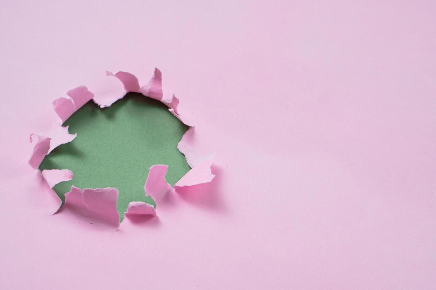 Ripped or torn pink paper frame with green copy space photo